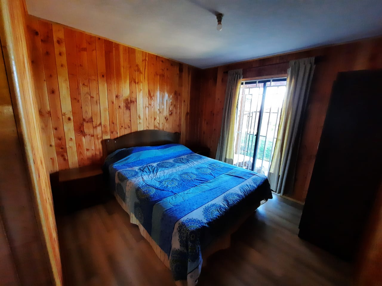 Dormitorio con cama matrimonial junto a la ventana